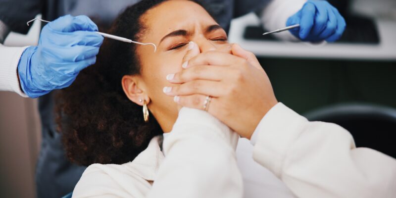 young woman covering her mouth, anxiety for root canal