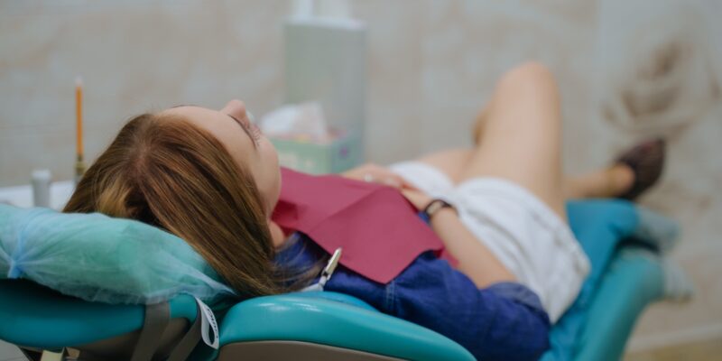 young woman calmly relaxing in a dental chair, sedation dentistry